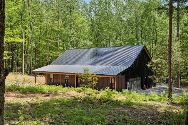 exterior space with an outdoor structure and a wooded view