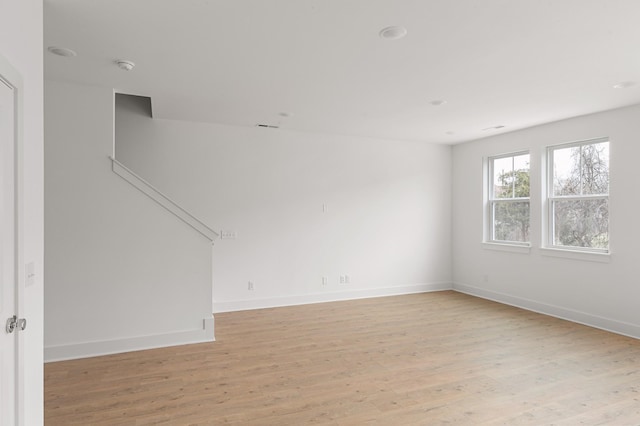spare room featuring light wood-style floors and baseboards