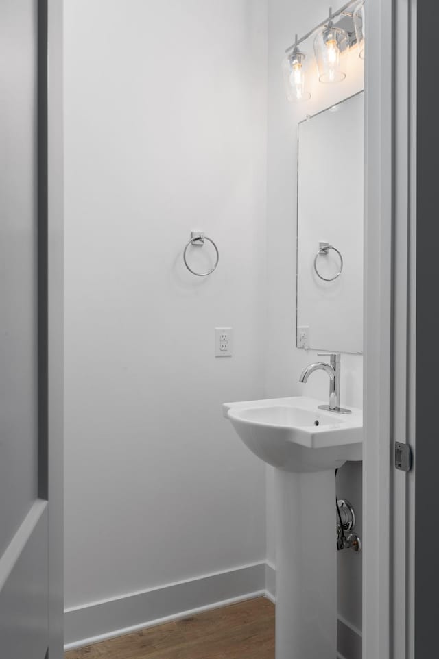 bathroom featuring a sink, wood finished floors, and baseboards
