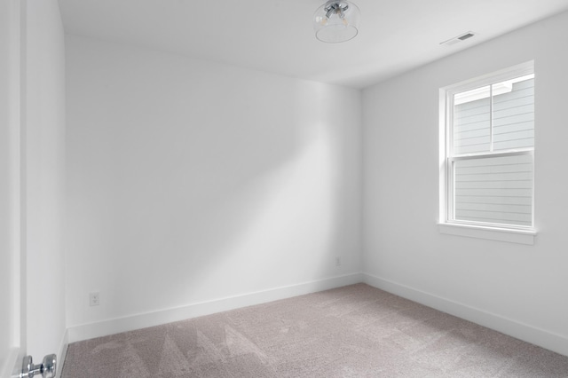 spare room with baseboards, visible vents, and carpet