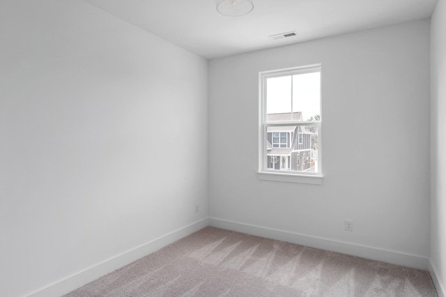 unfurnished room with light colored carpet, visible vents, and baseboards
