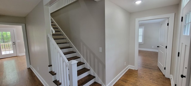 stairway featuring recessed lighting, wood finished floors, and baseboards