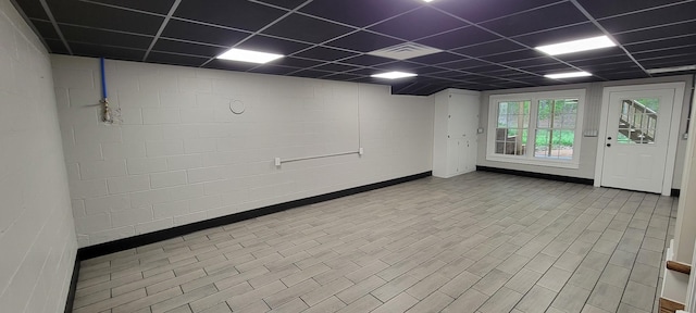 basement featuring a drop ceiling and baseboards