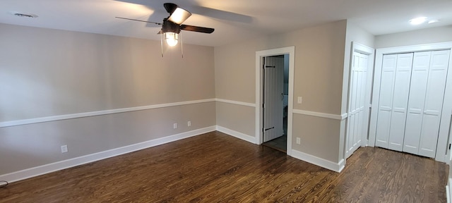 unfurnished bedroom with baseboards, a ceiling fan, and dark wood-type flooring