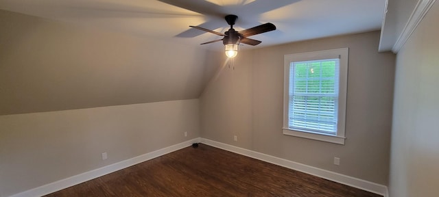 additional living space with baseboards, a ceiling fan, dark wood-type flooring, and vaulted ceiling