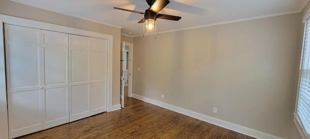 unfurnished bedroom with a closet, ornamental molding, dark wood-style floors, and baseboards