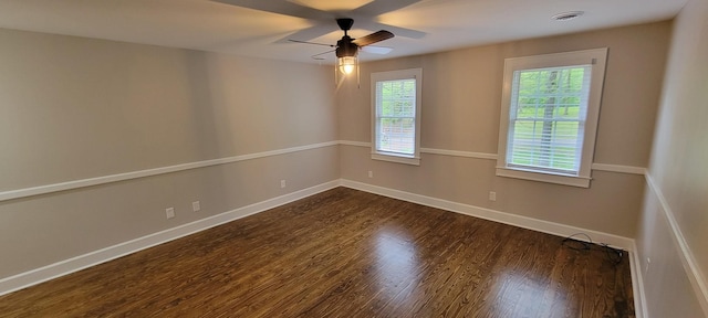 spare room featuring a ceiling fan, dark wood-style flooring, visible vents, and baseboards