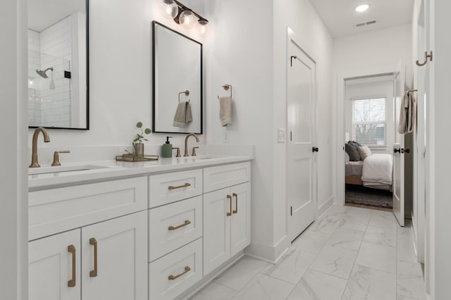 full bath with a tile shower, baseboards, marble finish floor, and a sink