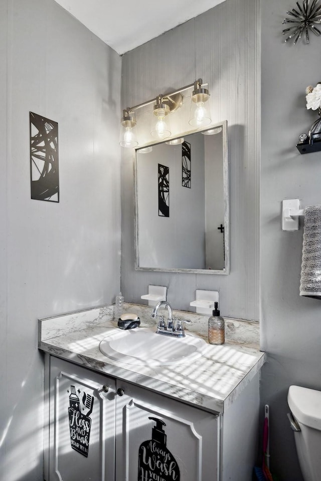 half bathroom with toilet and vanity