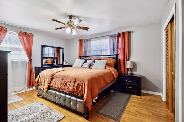 bedroom featuring light wood-style flooring, baseboards, a closet, and a ceiling fan