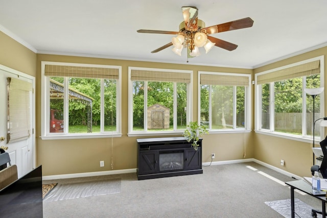 unfurnished sunroom with baseboards, ornamental molding, and carpet floors