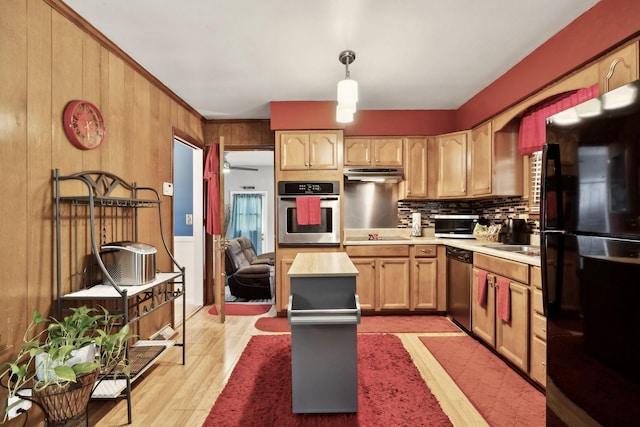 kitchen featuring black appliances, light countertops, exhaust hood, decorative backsplash, and light wood finished floors
