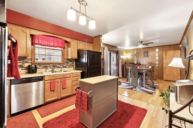 kitchen featuring stainless steel dishwasher, a sink, freestanding refrigerator, a ceiling fan, and decorative backsplash