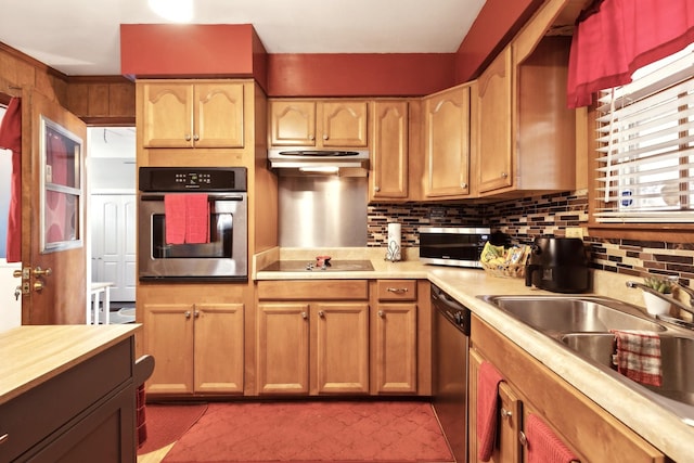 kitchen with stainless steel appliances, light countertops, under cabinet range hood, and backsplash