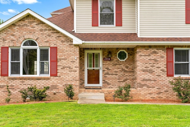 2938 Heatherfield Dr, Woodlawn, TN 37191 - property entrance with a lawn, a shingled roof, and brick siding