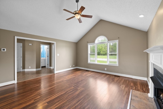 2938 Heatherfield Dr, Woodlawn, TN 37191 - unfurnished living room featuring a fireplace with flush hearth, wood finished floors, a ceiling fan, lofted ceiling, and baseboards