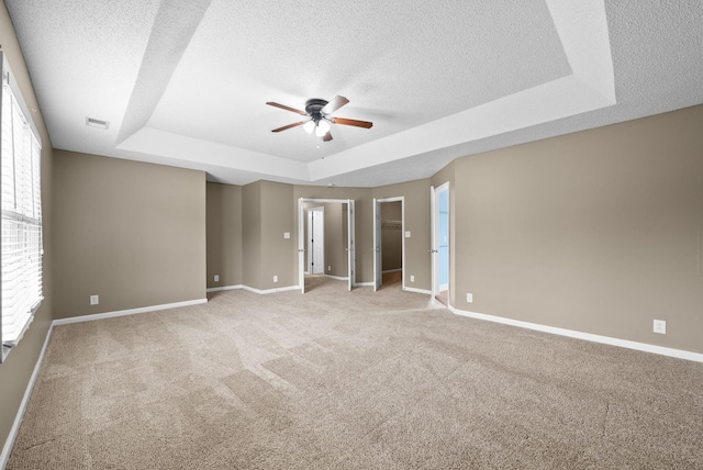 2938 Heatherfield Dr, Woodlawn, TN 37191 - empty room featuring a raised ceiling, a ceiling fan, a textured ceiling, light carpet, and baseboards