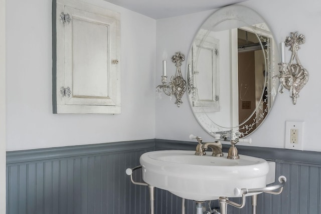 bathroom featuring a wainscoted wall and a sink