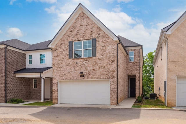 view of front of house with a garage, brick siding, driveway, and central air condition unit