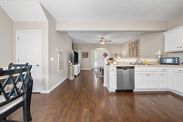 kitchen featuring white cabinetry, stainless steel dishwasher, a sink, dark wood-style floors, and a peninsula