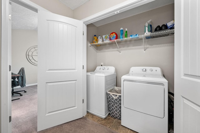 laundry area with a textured ceiling, washing machine and clothes dryer, and laundry area