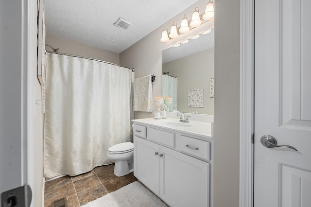 bathroom with visible vents, toilet, a textured ceiling, and vanity