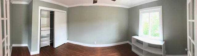 interior space with a ceiling fan, ornamental molding, dark wood finished floors, and baseboards
