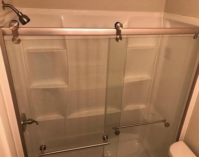 full bathroom featuring toilet and a shower