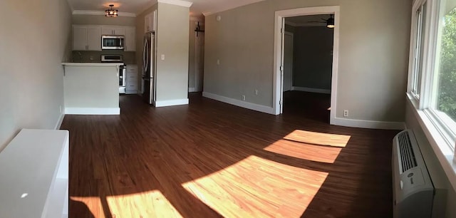 spare room with a wall mounted AC, crown molding, a ceiling fan, baseboards, and dark wood finished floors