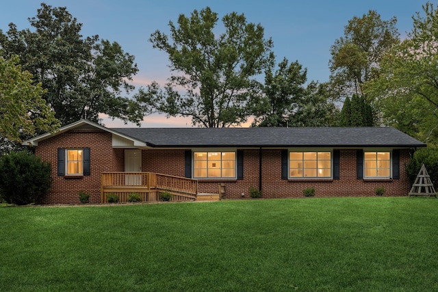 single story home with brick siding and a yard