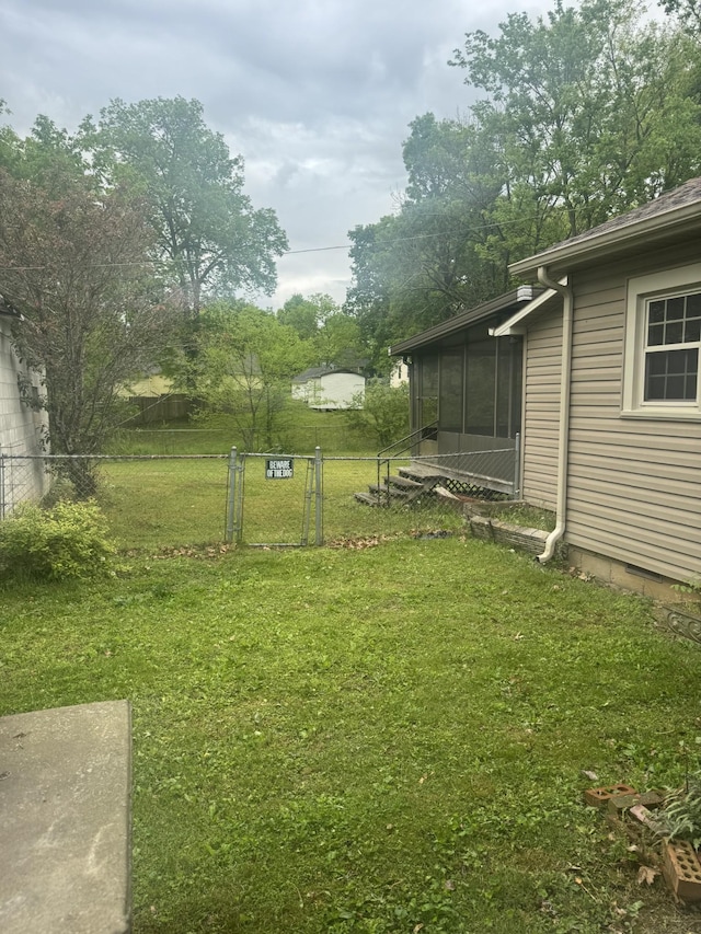 view of yard featuring fence and a sunroom
