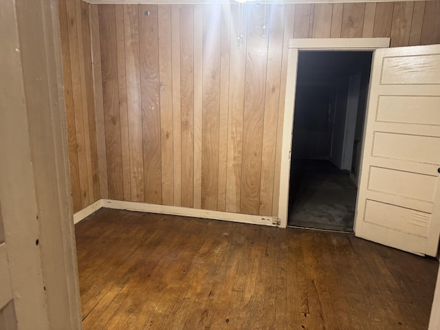 unfurnished room with wooden walls and wood-type flooring
