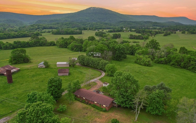 aerial view at dusk featuring a mountain view and a rural view
