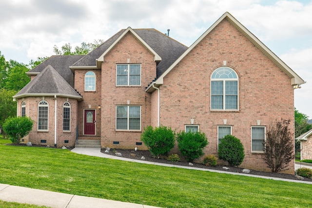 view of front of home featuring roof with shingles, brick siding, a front lawn, and crawl space