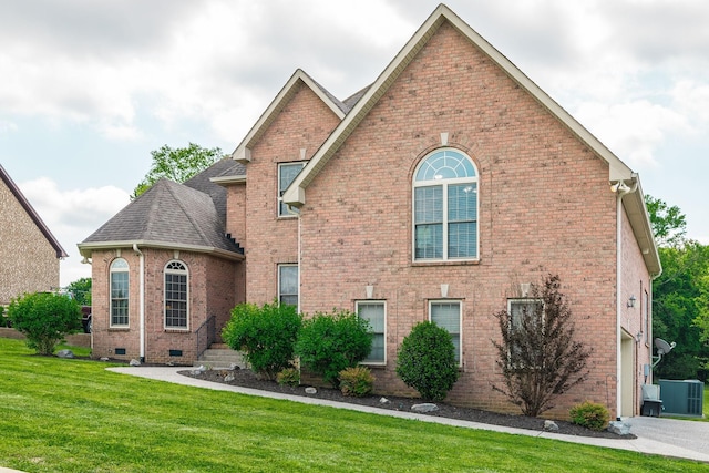 view of front of property with central AC unit, a shingled roof, a front lawn, and brick siding