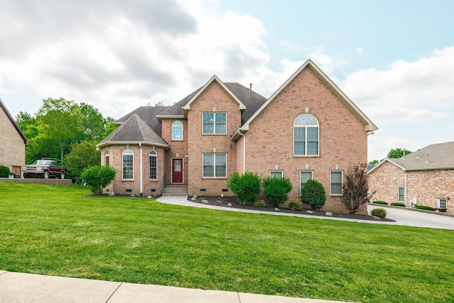 view of front of property with a shingled roof, a front yard, brick siding, and crawl space