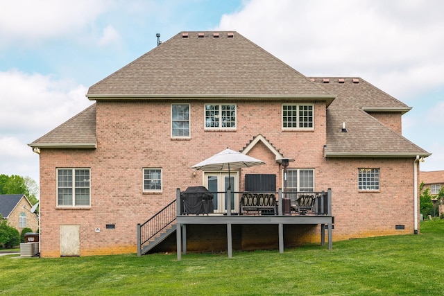 rear view of property featuring a shingled roof, brick siding, a deck, crawl space, and a lawn