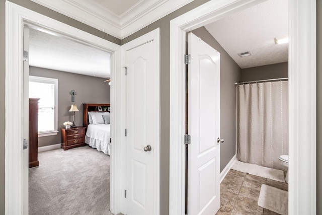 hallway featuring carpet floors, baseboards, and visible vents