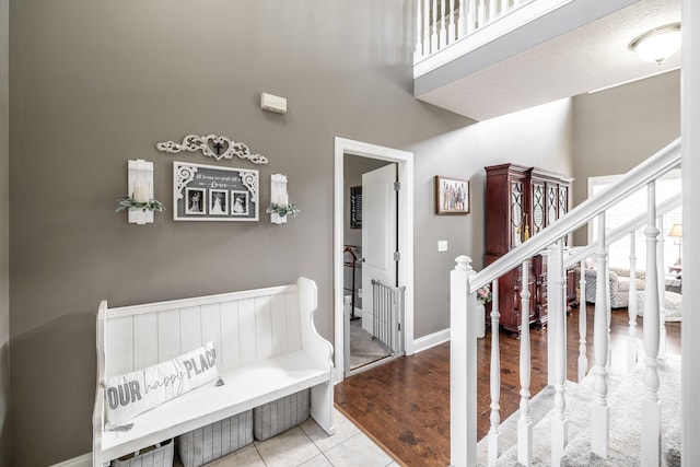 entryway featuring stairs, a towering ceiling, and wood finished floors