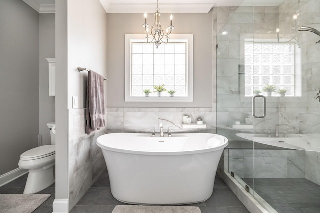 bathroom with a stall shower, a chandelier, a soaking tub, and tile walls