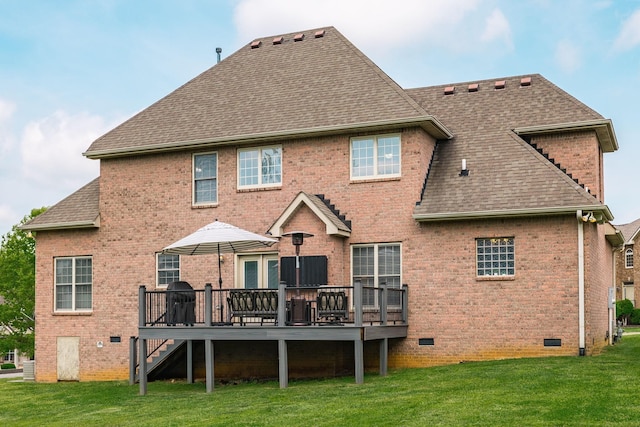 rear view of property featuring a deck, roof with shingles, brick siding, crawl space, and a lawn
