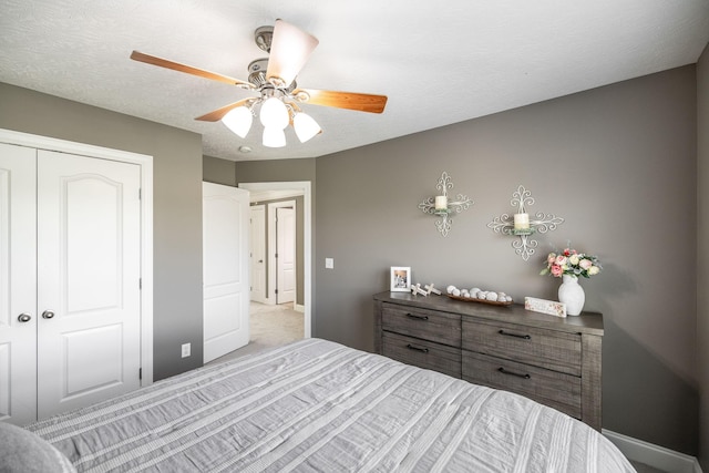 carpeted bedroom with a closet, baseboards, and a ceiling fan