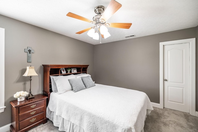 carpeted bedroom featuring visible vents, a ceiling fan, and baseboards