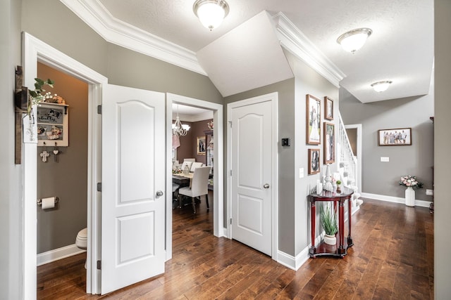 hall with baseboards, an inviting chandelier, ornamental molding, and wood finished floors