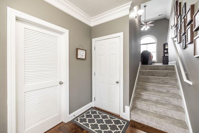 foyer with crown molding, stairs, baseboards, a ceiling fan, and dark wood finished floors