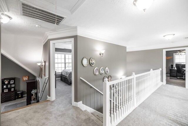 corridor with attic access, carpet, baseboards, an upstairs landing, and visible vents