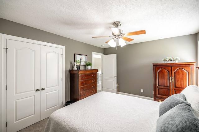 carpeted bedroom featuring a ceiling fan, baseboards, a textured ceiling, and a closet