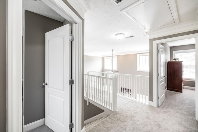 corridor with visible vents, baseboards, carpet, and attic access