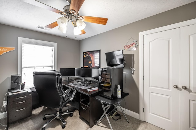 carpeted office space with visible vents, a ceiling fan, and baseboards