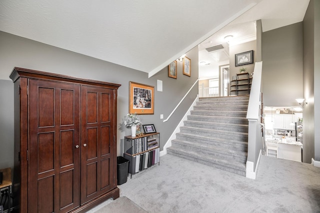 stairway with carpet flooring, baseboards, and visible vents